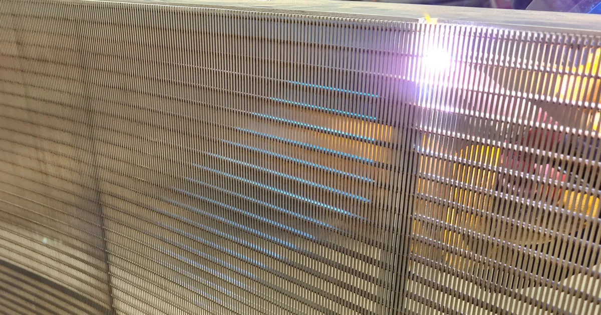 TIG welding on a Coanda intake screen in the workshop, the arc lit against its wedge-wire surface