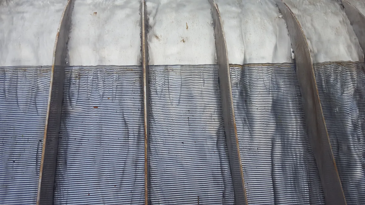 Close view of the curved wedge-wire face of an installed Coanda screen