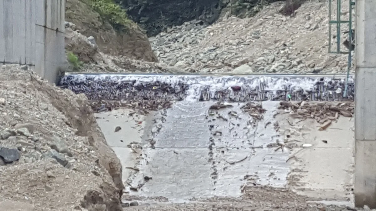A large river intake structure with the channel in front of it filled with gravel after high flow
