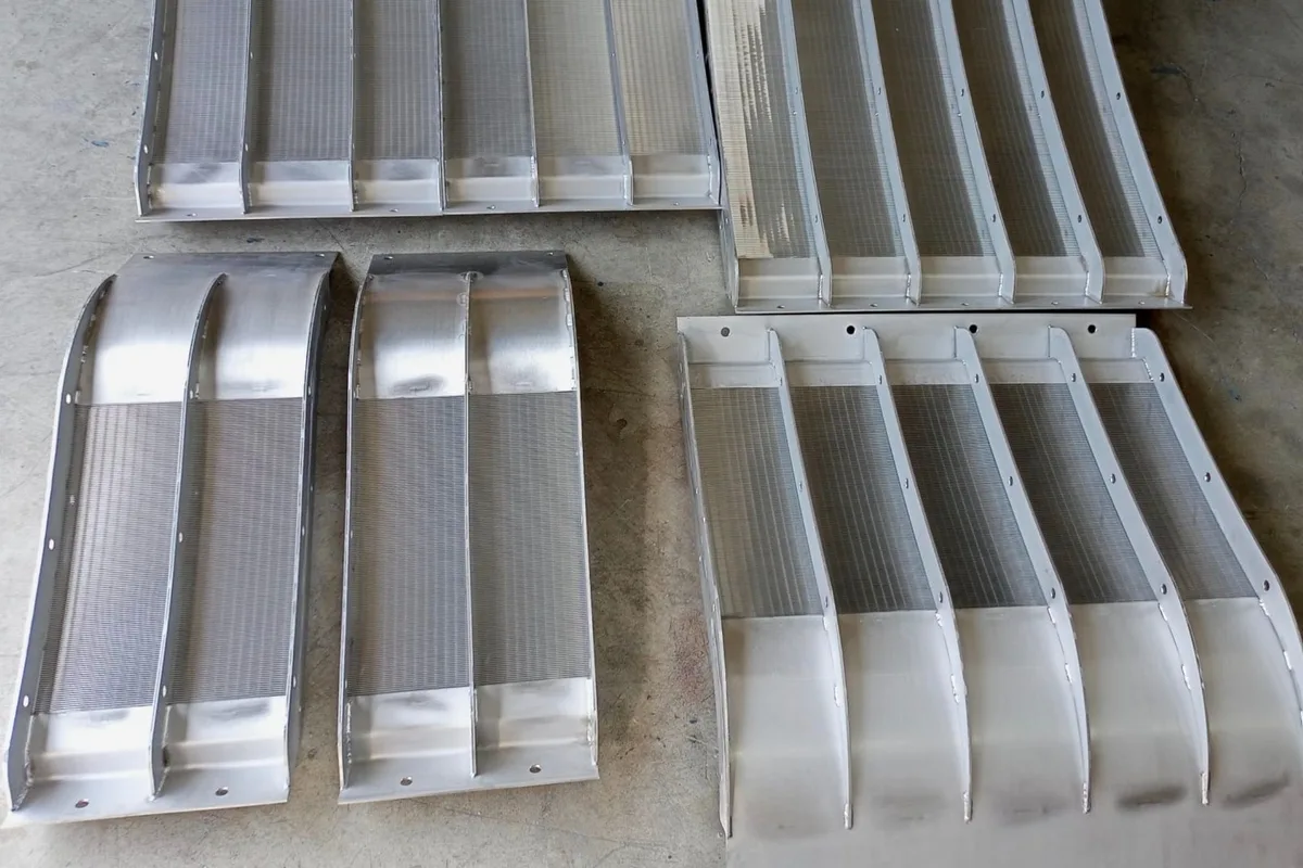 Several Coanda screen units of different widths laid out side by side on the ground