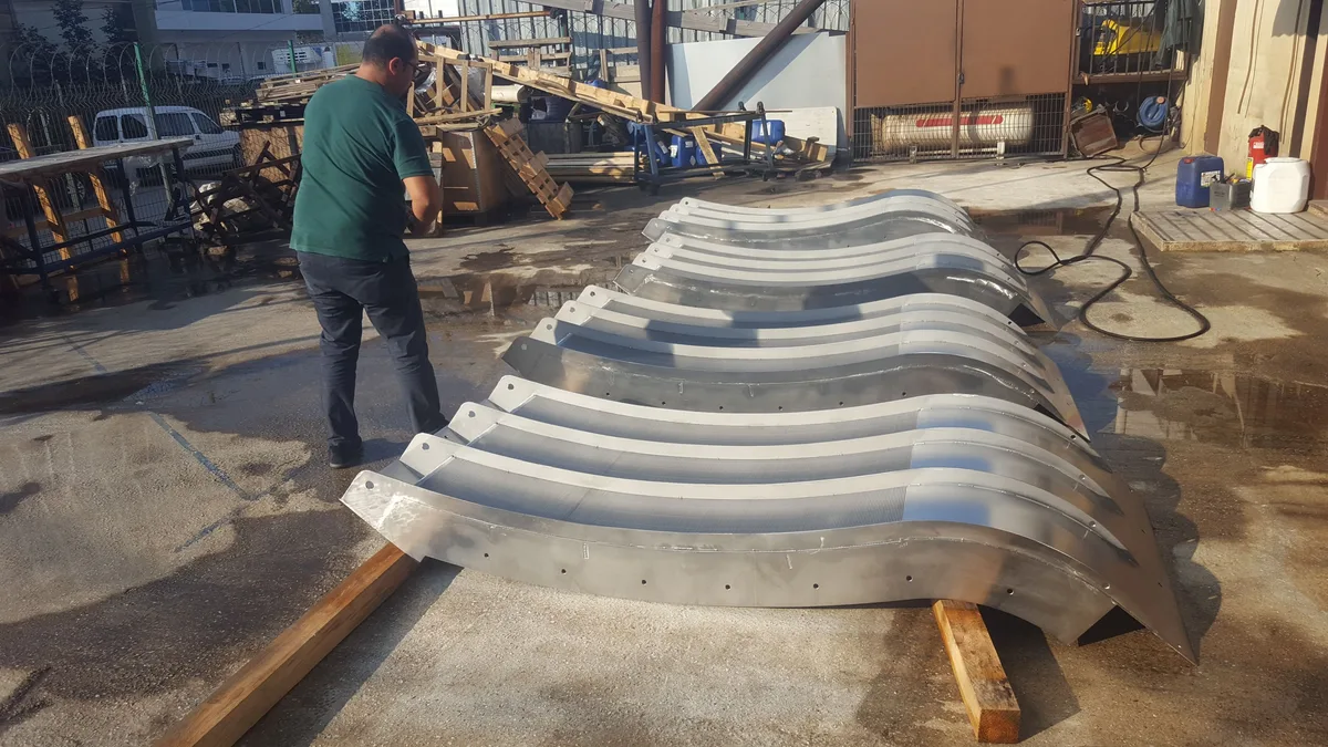 Formed Coanda screen bodies lined up on the workshop floor