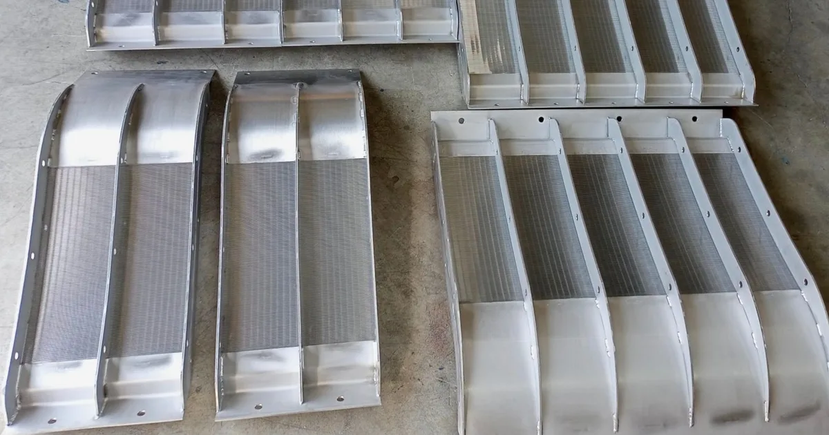 Several Coanda screen units of different widths laid out side by side on the ground