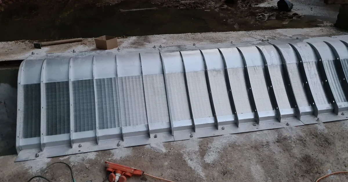 A long Coanda intake screen run along the wall of a concrete channel