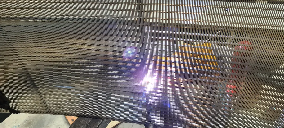 TIG welding on a Coanda intake screen in the workshop, the arc lit against its wedge-wire surface