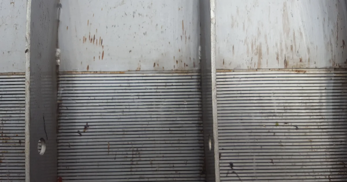 The wedge-wire face of a Coanda screen after a period in service, with mineral staining across the surface