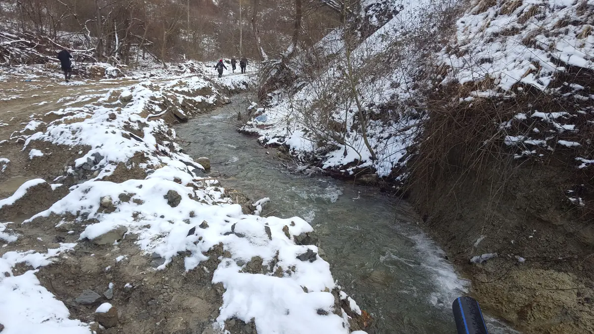 Kanalında bir su alma yapısı bulunan karla kaplı bir dere vadisi