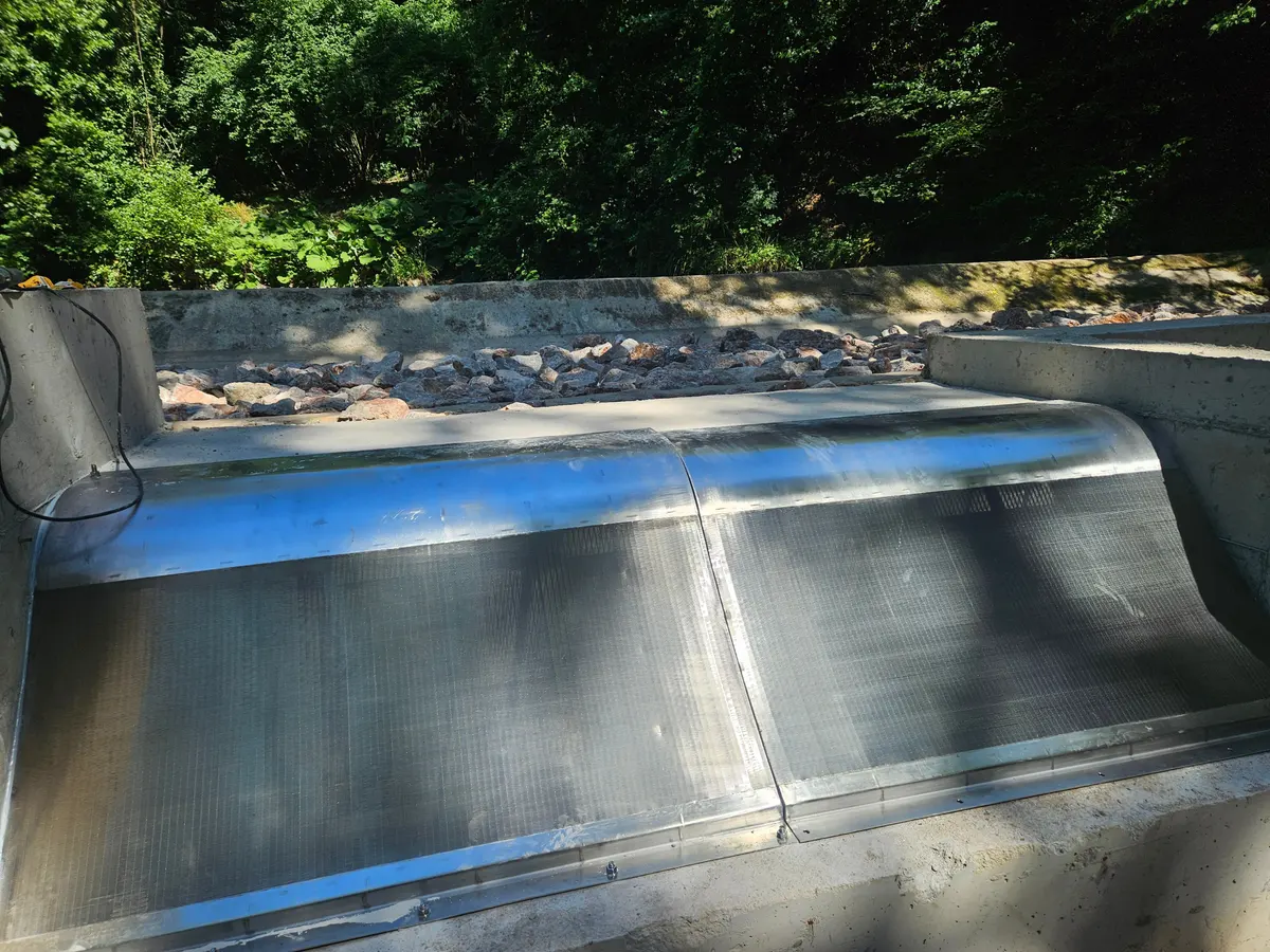 A new Coanda intake screen fitted into an existing concrete intake structure, protective film still on the surface