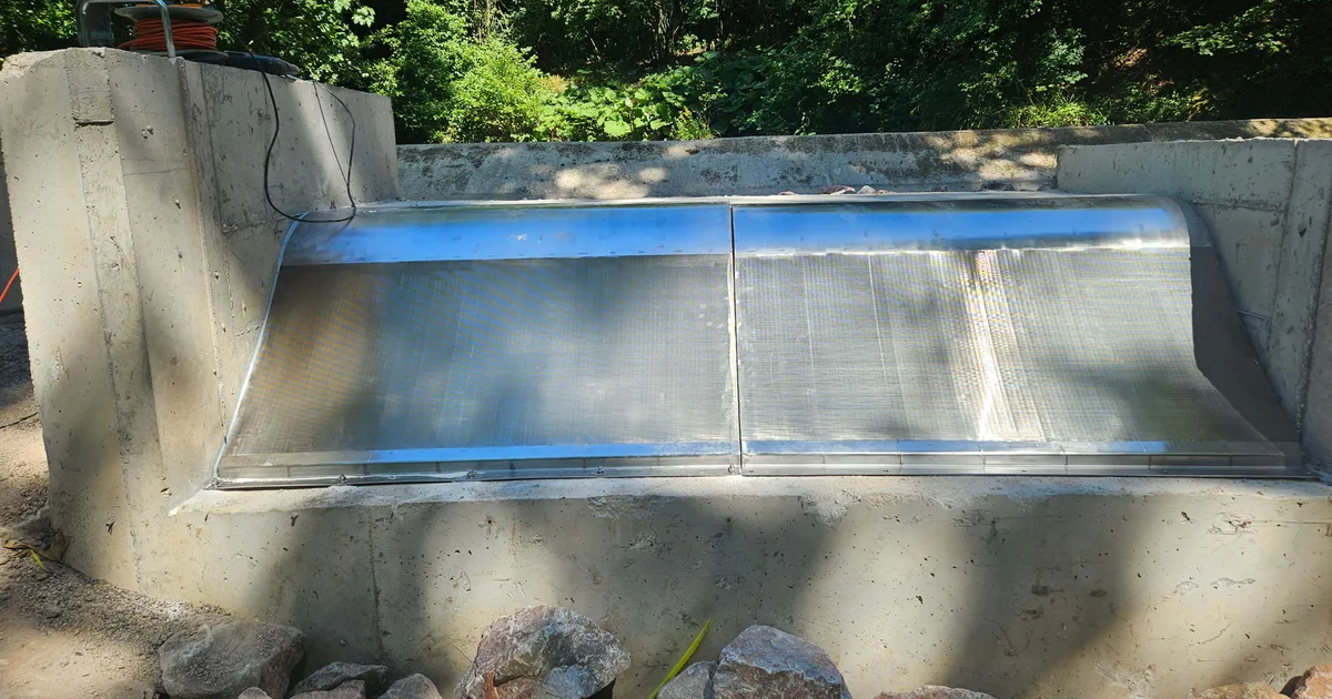 A new Coanda intake screen fitted into an existing concrete intake structure, protective film still on the surface