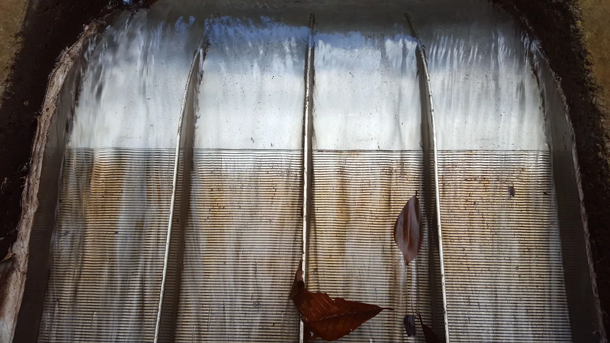 Nahansicht des Wassers, das die Keildraht-Spalte auf der gekrümmten Fläche eines Coanda-Rechens überströmt