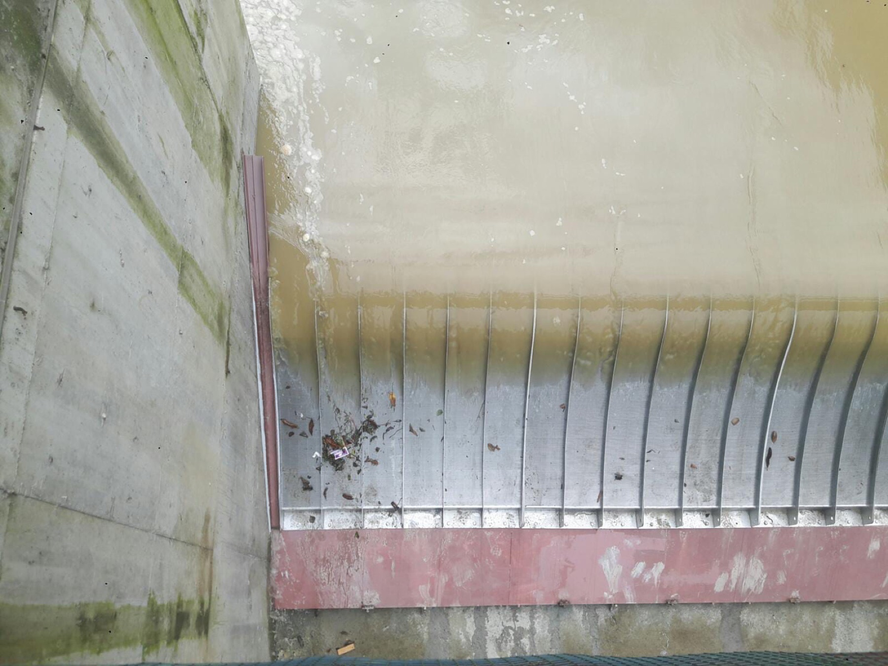 Seydioğlu HPP (hydropower plant) intake after the Coanda retrofit, water flowing in a clean, thin sheet over the screen face