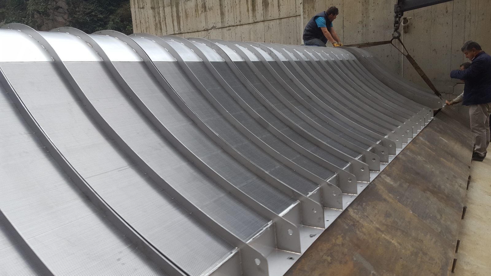 مهندسو ADENCO ينزلون شبكة كواندا كبيرة لمأخذ المياه إلى منشأ المأخذ الخرساني باستخدام حبال الرفع أثناء التركيب