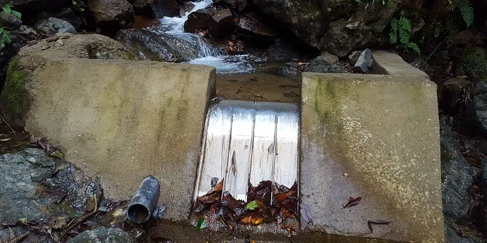 Rejilla de toma Coanda ADENCO-70-0.75, toma de 50 l/s para agua potable, rejilla Coanda sobre un azud en un arroyo rocoso con las hojas arrastradas aguas abajo, Trabzon, Türkiye