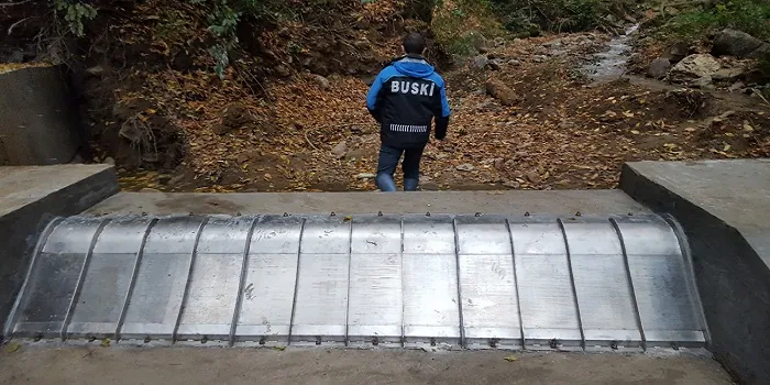 Rejillas de toma Coanda 3 x ADENCO-45-1, toma de 105 l/s para riego, rejilla Coanda ancha sobre un azud bajo con un ingeniero inspeccionándola, Bursa, Türkiye