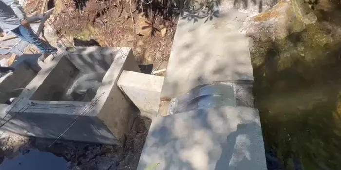 Rejilla de toma Coanda ADENCO-45-0.30, toma de 10 l/s para agua potable, rejilla Coanda pequeña en una caja de toma de hormigón iluminada por el sol, Trabzon, Türkiye