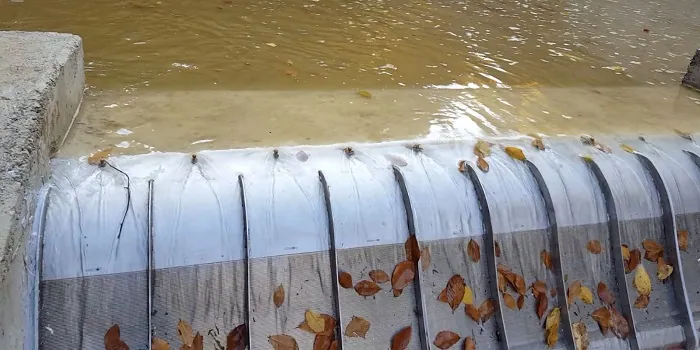 Rejillas de toma Coanda 3 x ADENCO-45-1, toma de 105 l/s para riego, rejilla Coanda sobre un azud con hojas de otoño arrastradas por encima, Bursa, Türkiye