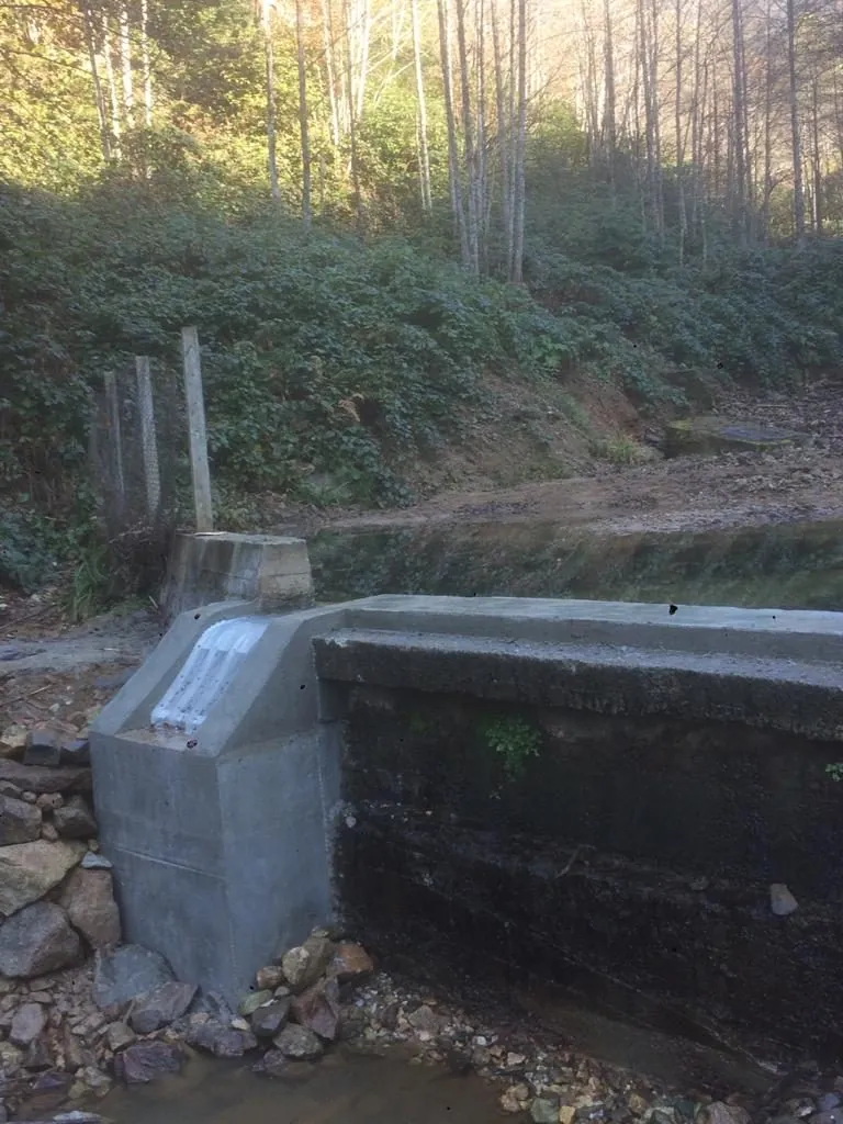 Rejilla de toma Coanda ADENCO-45-0.45, toma de 15 l/s para agua potable, rejilla Coanda sobre un azud en un bosque otoñal, Trabzon, Türkiye